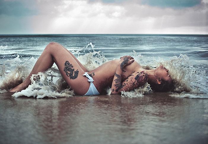 Naked tattoo girl on the beach