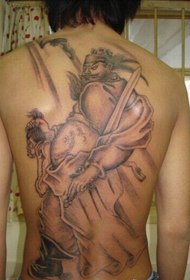 Мужская спина полна властных колокольчиков и татуировок