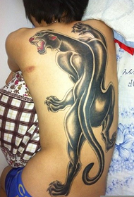 Moški hrbet s črno hrbtno tetovažo leoparda