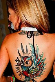 Woman's beautiful tattooed colorful owl tattoo on her back