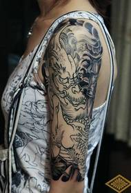 domineering arm black and white unicorn tattoo