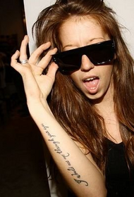Euroopa-Ameerika tüdruku käsi ingliskeelse sõna tattoo peal