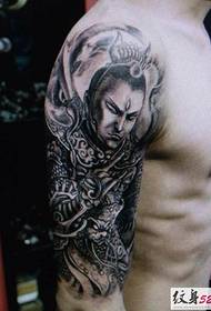bruņota roka uz personību, kurā dominē Erlanga dieva Janga Lan tetovējums
