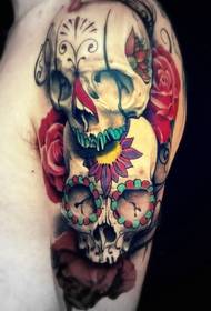 two skull and rose tattoos on the arm