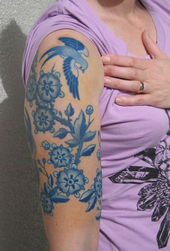cánh tay lớn của nữ trên hình xăm màu xanh và trắng