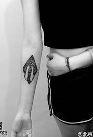 Malé totemové tetování na paži