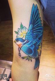 Ilustración de tatuaje de golondrina en color del brazo