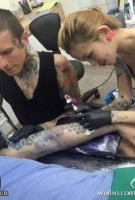 Художник-татуировщик во время операции татуировки