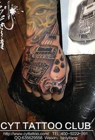 Personlig tatovering med musikkinstrument på baksiden av hånden