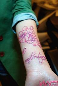 Слика свеже ружичасте мале тетоваже на руци брескве