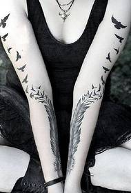 Noia de bellesa amb plomes i tatuatges de aus marines amb motius de tatuatges
