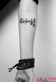 Black and white Tibetan arm tattoo