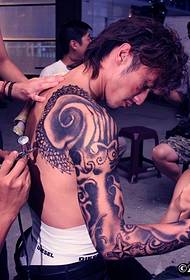 Zvaigzne Nikolass Tse parāda rokas tetovējumu
