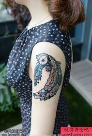 Woman arm colored owl tattoo work