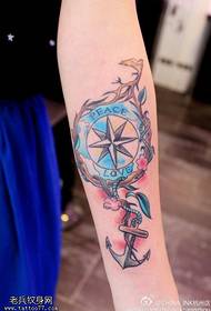 Woman arm color compass anchor tattoo work