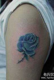 Ramię dziewczynki w realistyczny wzór tatuażu w kolorze róży
