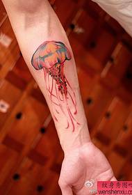 un model de tatuaj de meduze colorate cu brațul unei femei