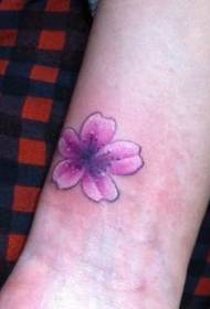 Brazo de niña pequeño y delicado patrón de tatuaje de flor de cerezo