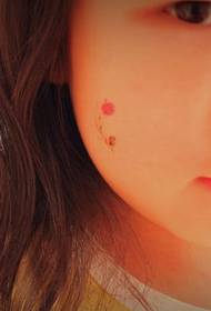 Adik perempuan menghadapi bunga merah lucu tato mikro segar