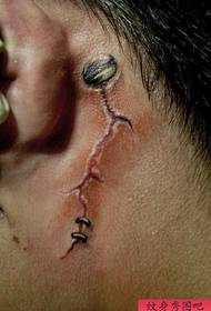 an alternative popular tear tattoo pattern on the ear