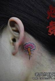 a dark cloud and small lightning tattoo pattern on the girl's ear