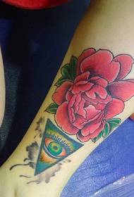 a bright red flower tattoo on the calf