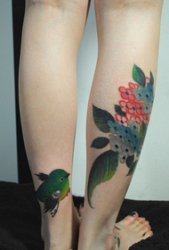 U vitellu femminile simpaticu tatuatu d'uccelli in prugna