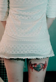 Ženske noge zgodnih ljubavnih krila s leopardovom tetovažom