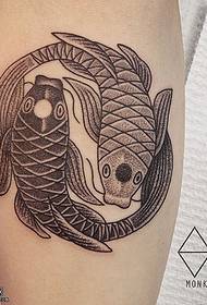 Dwa małe tatuaże rybne na łydce