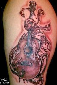 Patron de tatuatge de guitarra feliç a la cama