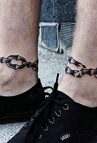 Чоловічі ноги припливів мають творчі малюнки татуювання ланцюга