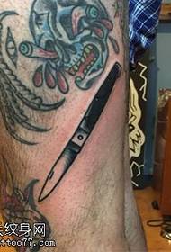 Motif de tatouage au couteau sur la jambe