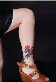 ขาของหญิงสาวสวยเพียง แต่ดูรูปแบบลายสักดอกกุหลาบที่สวยงาม