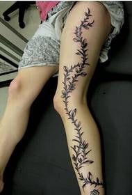 Divatos női lábak, egy gyönyörű és gyönyörű virágos szőlő tetoválás képe