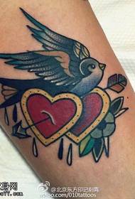 Painted bird with a heart piercing tattoo pattern