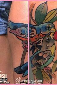 Duas tatuagens de pássaros na panturrilha