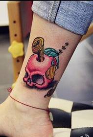 Stilīgas sieviešu kājas jauki izskatās krāsainā ābolu tetovējuma attēlā