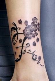 Mergaitės jade kojos vyšnių žiedų vynuogių tatuiruotės modelio nuotrauka
