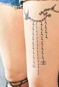 Imagine de tatuaj în lanț proaspăt și frumos pe coapsa fetei