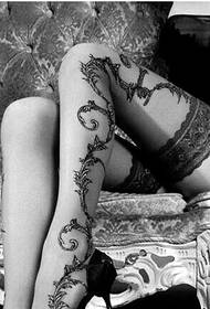 写真を楽しむ女性のセクシーな脚のつるマントルのタトゥーの写真