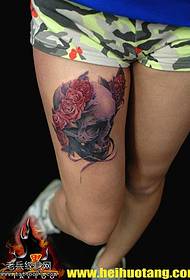 Noga žena glamurozan uzorak tetovaža lubanje cvijeta