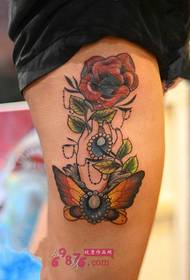 Hand holding rose scented thigh tattoo picture