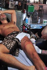 Escena de tatuaje de pernas de artista masculino europeo e americano