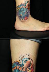 Perna da menina bonita com padrão de tatuagem de andorinha colorida