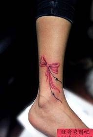 女孩腿上精美的蝴蝶結紋身圖案
