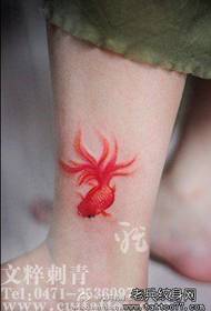 Noge deklet obarvane majhne vzorce tetovaže z zlatimi ribami