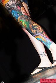 a woman's traditional flower leg tattoo work