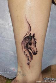 Una tendenza classica del tatuaggio del cavallo sulla gamba della ragazza