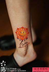 Noga slatko osmiješno lice s cvjetnim uzorkom tetovaže