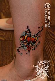 A woman's ankle color small crown tattoo works by tattoos